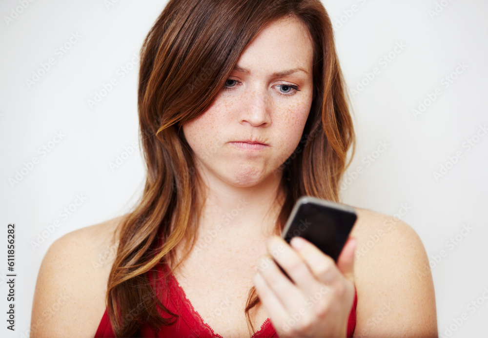 Phone, text message and an angry woman in studio on a white background unhappy while reading bad news. Social media, internet and app with a young female looking upset while checking her mobile inbox Phone, text message and an angry woman in studio on a white background unhappy while reading bad news. Social media, internet and app with a young female looking upset while checking her mobile inbox