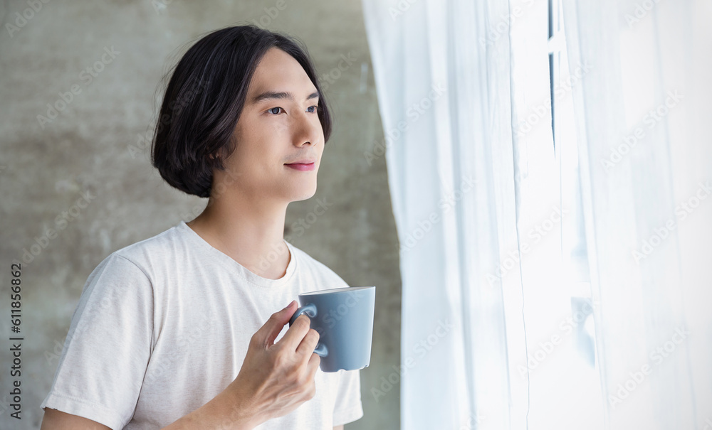 Portrait of young handsome asian man hand on coffee mug in bedroom. Smile happy asian boy in bed morning lifestyle near window. Japanese man leisure time on weekend, minimal modern break time concept