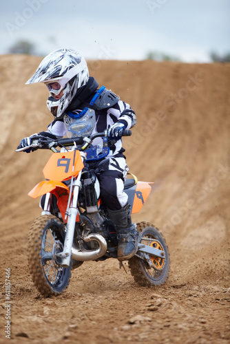 Motorcycle, sports and a child rider on a dirt track for racing, adventure or adrenaline outdoor during a hobby. Fitness, children and freedom with a boy kid on a bike for speed training or challenge
