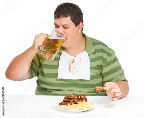 Obesity  man and fast food with alcohol  unhealthy and guy isolated against a white studio background. Obese  male person and model with beer  chicken wings and eating with a bib  fries and hungry