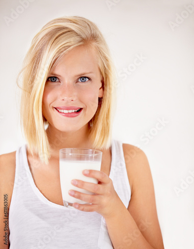 Portrait, milk and health with a woman drinking from a glass in studio isolated on a white background. Healthy, nutrition and calcium with a young female enjoying a drink for vitamins or minerals