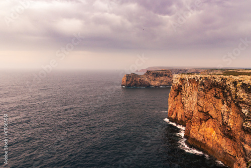 Cliffs at Cabo de San Vicente,with the Stone of the Seagulls in the background,Sagres,Portugal.
