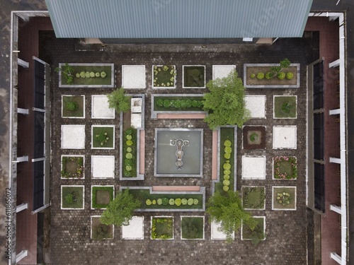 Captured using a drone, the view from above reveals an aesthetically pleasing layout of a garden that resembles a maze with square-shaped patterns.