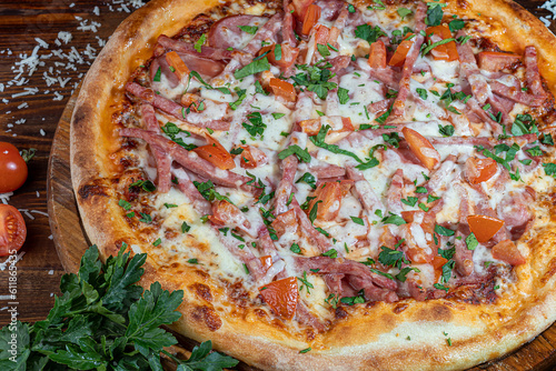 Pizza with bacon and cheese, herbs and cherry tomatoes. With mozzarella, shrimps and octopuses, mussels and other products on a wooden background.