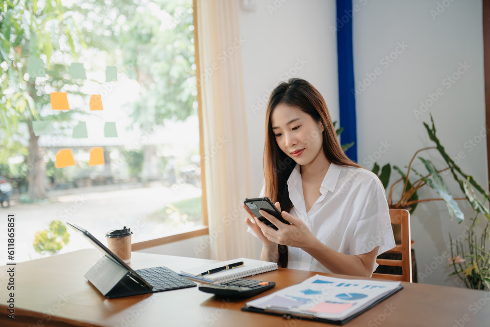 Young attractive Asian female office worker business suits smiling on desk in home office Young attractive Asian female office worker business suits smiling on desk in home office
