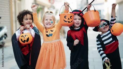 Group of kids wearing halloween costume holding pumpkin basket at street