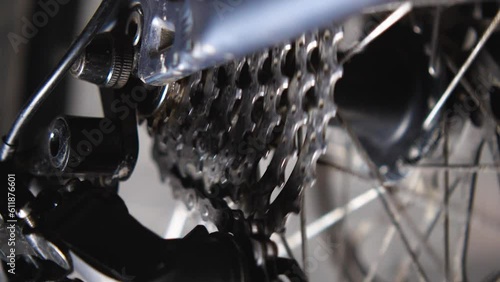 Close-up of a rotating bicycle wheel and cassette. Checking the operation of the transmission after repairs. Bicycle repair and maintenance workshop. Slow motion