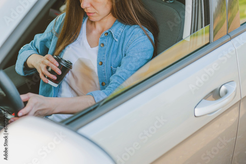 Slika na platnu Female spilling coffee or tea on herself while driving a car