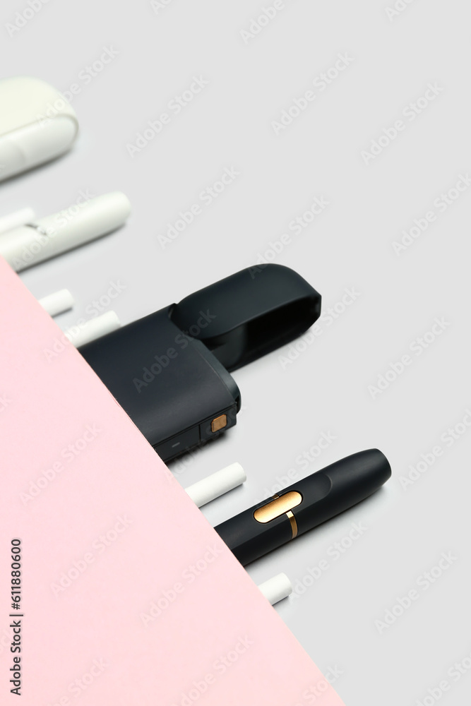 Composition with different electronic cigars on grey background Composition with different electronic cigars on grey background