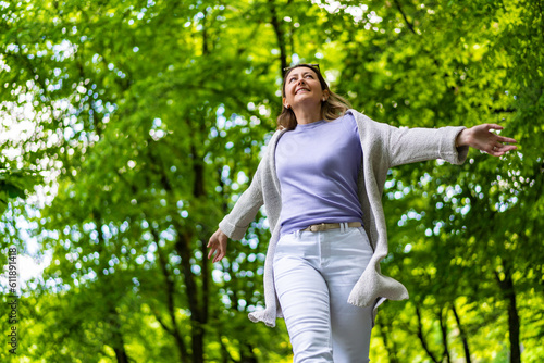 Fototapeta Beautiful woman walking in city park