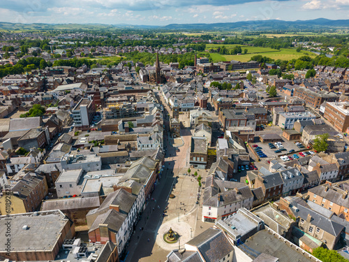 This aerial drone photo shows the town of Dumfries in the district of Dumfries and Galloway in Scotland. You can see High Street, which is the main shopping street in this town. 