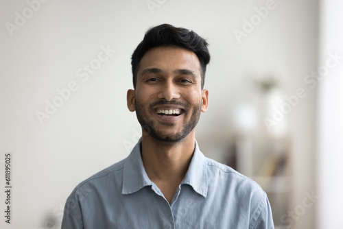 Happy handsome young Indian man head shot front portrait. Cheerful successful entrepreneur, startup leader, business professional in casual looking at camera with toothy smile photo