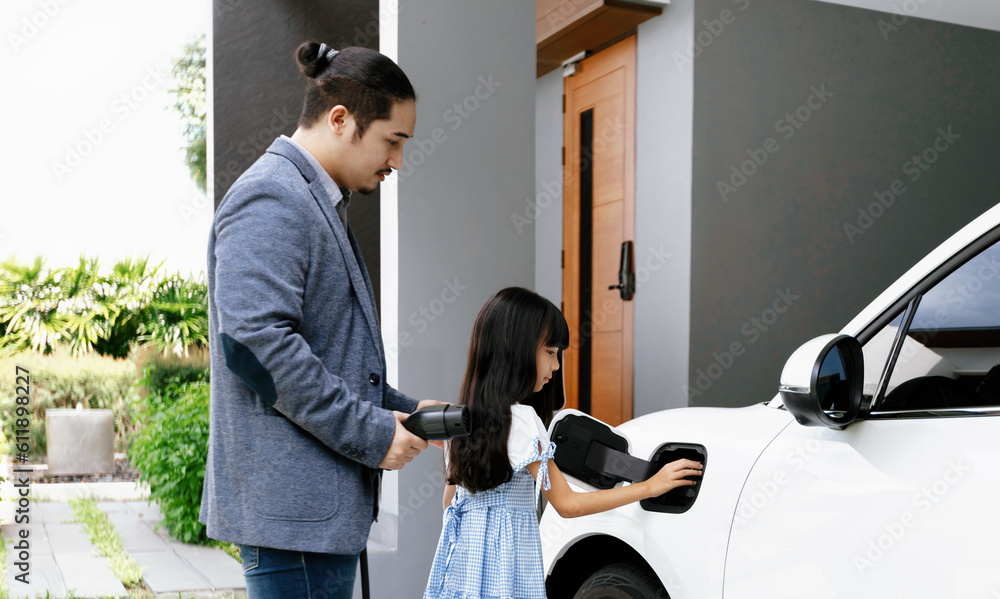 Progressive father and daughter plugs EV charger from home charging
