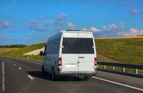 Minibus Carries Passengers on a suburban Highway in the summer.