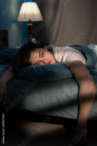 Φωτογραφία Dramatic portrait in the dark of depressed woman on bed suffering crisis and anxiety lying sleepless in insomnia