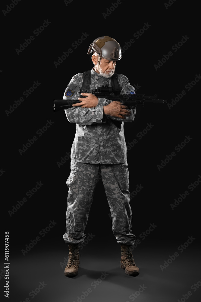 Mature soldier with assault rifle on dark background Mature soldier with assault rifle on dark background