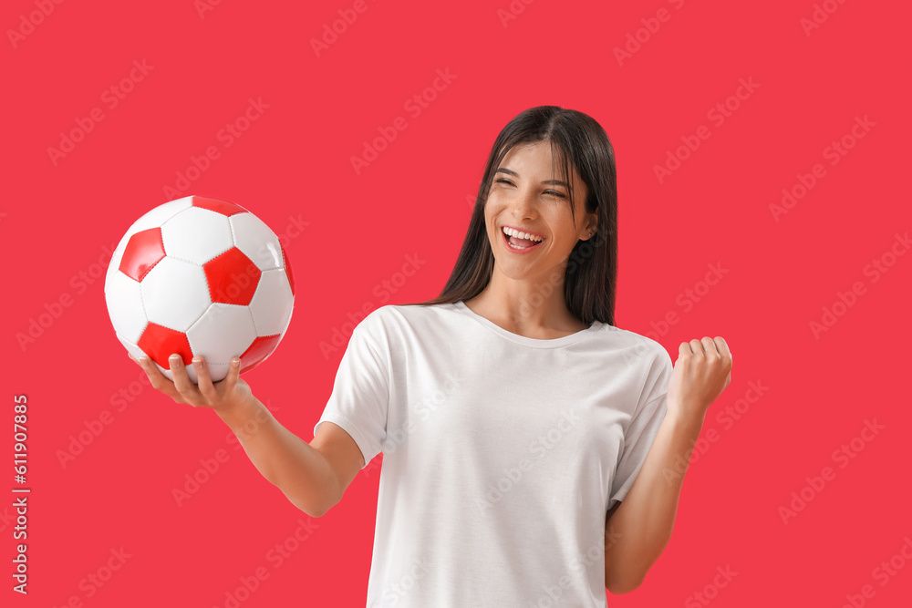 Happy young woman with soccer ball on red background Happy young woman with soccer ball on red background