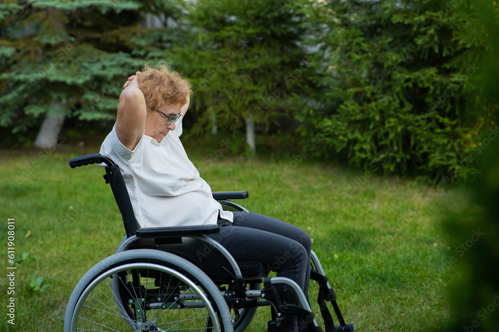 Elderly caucasian woman doing exercises while sitting in a wheelchair outdoors. Elderly caucasian woman doing exercises while sitting in a wheelchair outdoors.