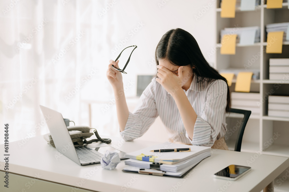 Asian business woman is stressed, bored, and overthinking from working on a tablet at the modern office. Asian business woman is stressed, bored, and overthinking from working on a tablet at the modern office.