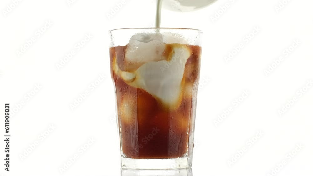 Pouring milk in coffee ice. Making iced coffee with milk Pouring milk in coffee ice. Making iced coffee with milk