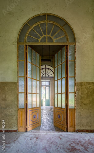 Vertikale Aufnahme einer schönen alten Glastür in einem verlassenem Gebäude. 