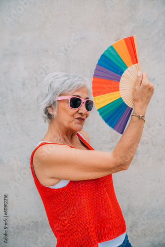 Wallpaper Mural Funny senior woman using colorful hand fan Torontodigital.ca