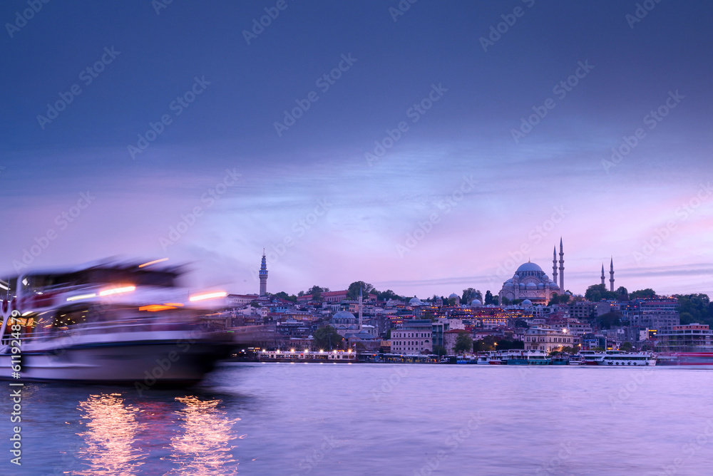 Istanbul cityscape - panoramic scenic view of mosque with ferry boat at sunset. Long exposure landscape of Istanbul at night