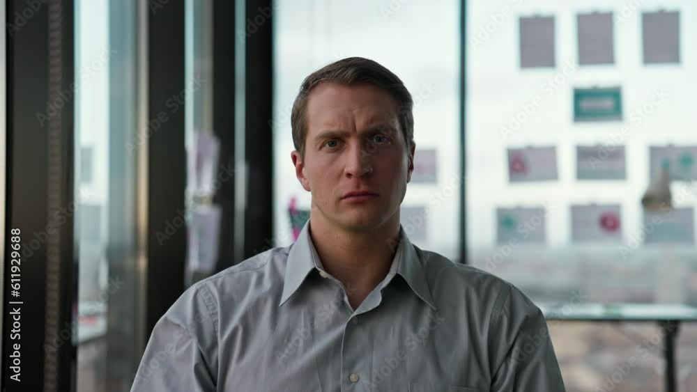 Businessman sits in office by window and looks ahead with concentration Businessman sits in office by window and looks ahead with concentration