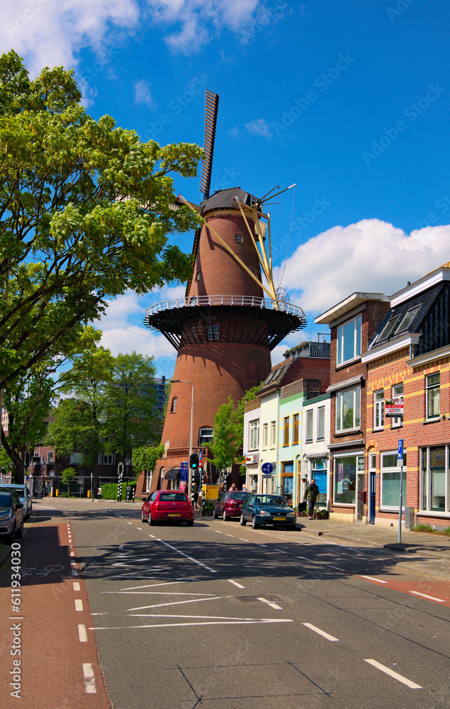 Obraz premium Utrecht, Netherlands-May 02, 2018:Landscape view of ancient street with traditional old mill and houses in Utrecht. Famous touristic place and travel destination in the Netherlands. Sunny spring day