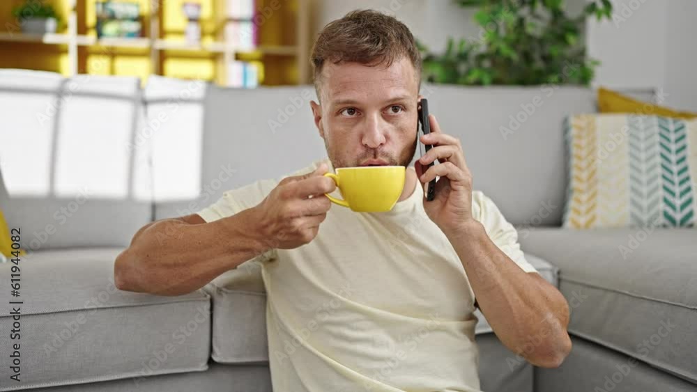 Young man talking on smartphone drinking coffee at home Young man talking on smartphone drinking coffee at home