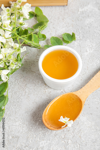 Composition with sweet honey and acacia flowers on light background, closeup