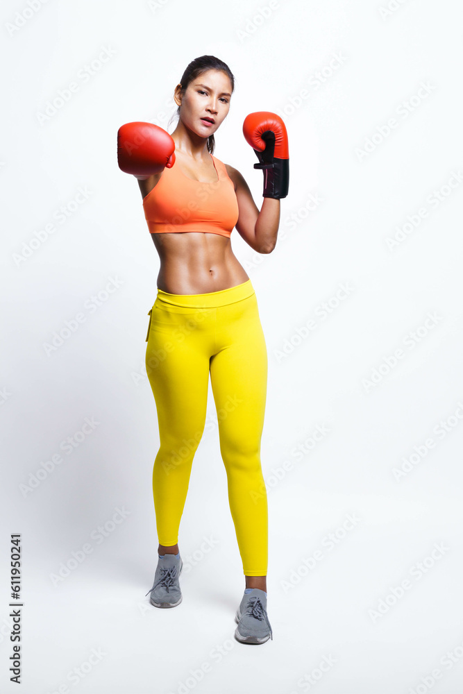 Asian woman with boxing gloves in fitness outfit while look up, isolated on yellow background. Asian woman with boxing gloves in fitness outfit while look up, isolated on yellow background.