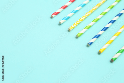 Different paper drinking straws on blue background