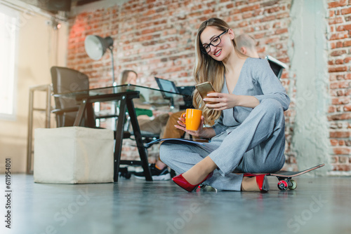 Woman in lofty office sitting on the floor working