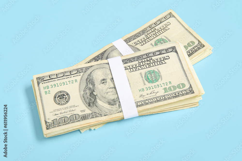 Bundles of one hundred dollar banknotes on blue background Bundles of one hundred dollar banknotes on blue background