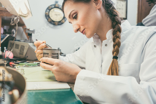 Bilde på lerret Diligent woman watchmaker working diligently on repairing a watch