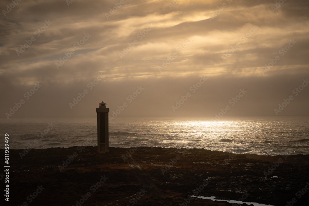 lighthouse on the beach at sunset