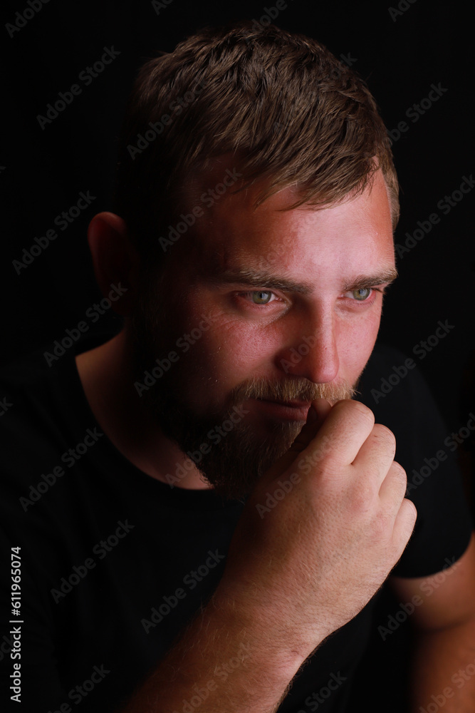 Thoughtful young bearded man on black background Thoughtful young bearded man on black background