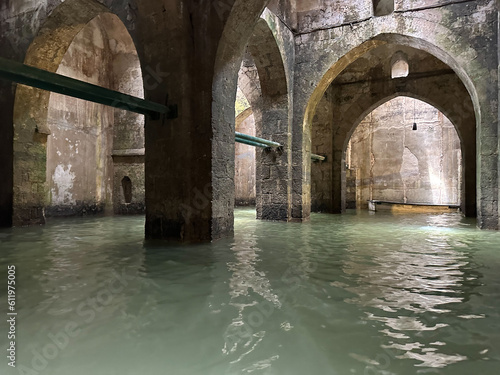 Underground reservoir with water. Columns of ancient stone building with old arched vaults. Complex used to store water. Tourists travel by boats to see inside.
