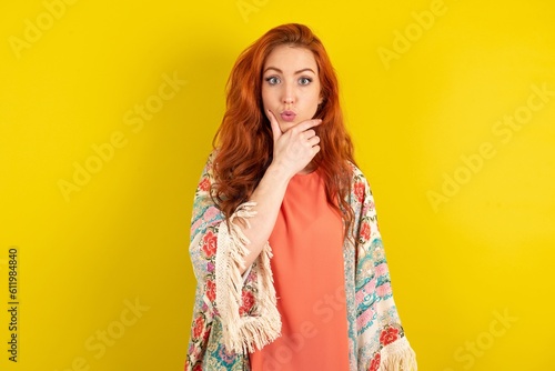 young beautiful red haired woman Looking fascinated with disbelief, surprise and amazed expression with hands on chin