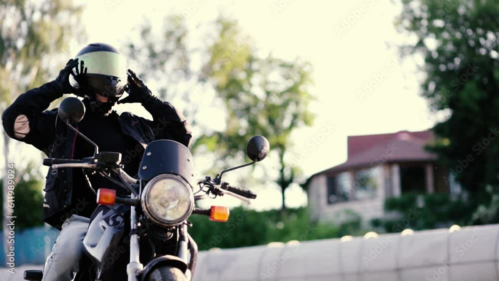 man taking off his motorcycle helmet. Confident serious male motorcyclist sitting on a motorbike. The concept of freedom and extreme life man taking off his motorcycle helmet. Confident serious male motorcyclist sitting on a motorbike. The concept of freedom and extreme life
