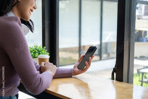 Closed up with Asian female using smartphone in front of laptop and phone, Closed up with blank screen of smartphone on female hand