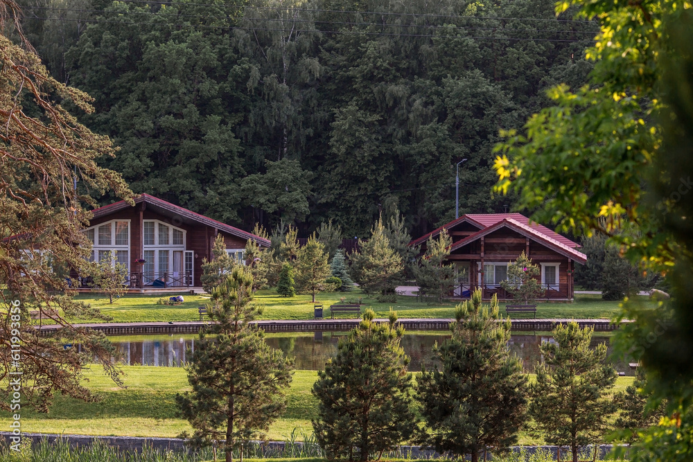 Fototapeta premium Modern wooden loft house for one family. Rent for privacy. An ideal place to relax. Wooden house by the water. Organic architecture. Minimalistic house with large panoramic windows for relaxation.