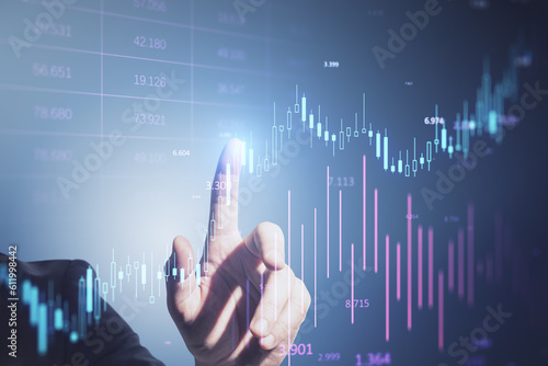 Close up of businessman hand pointing at glowing candlestick forex chart and index bar on blurry background. Investment, profit and financial growth concept. Double exposure.
