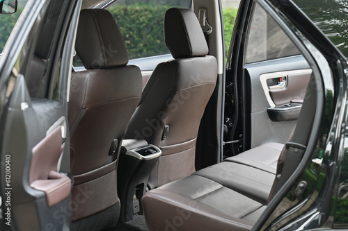 inside the back seat The passenger seat is wide and clean. Leather interior design, car passenger and driver seats, clean, angle view side, sunroof solar, buttons, dashboard, nappa leather, beige. © chatchai