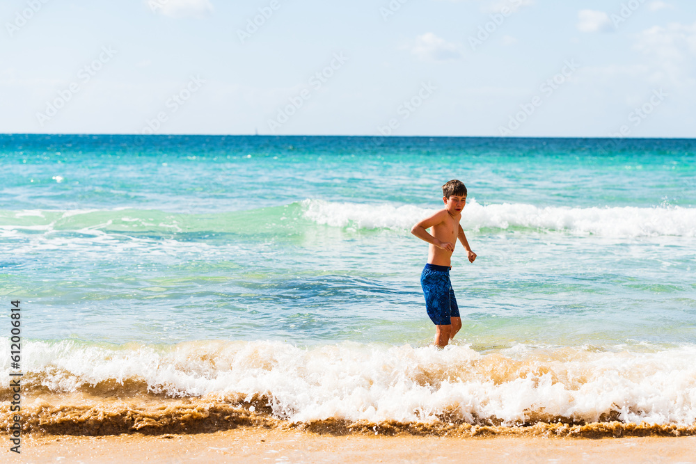 Boy in blue swimming trunks standing by waters edge, Alvor, Algarve, Portugal, Europe Boy in blue swimming trunks standing by waters edge, Alvor, Algarve, Portugal, Europe