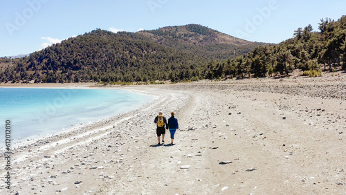 Couple hold hands walking Lake Salda romantic Turkish deserted beach 