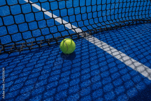 blue paddle tennis court netting casting its shadow on a ball, racket sports © Vic