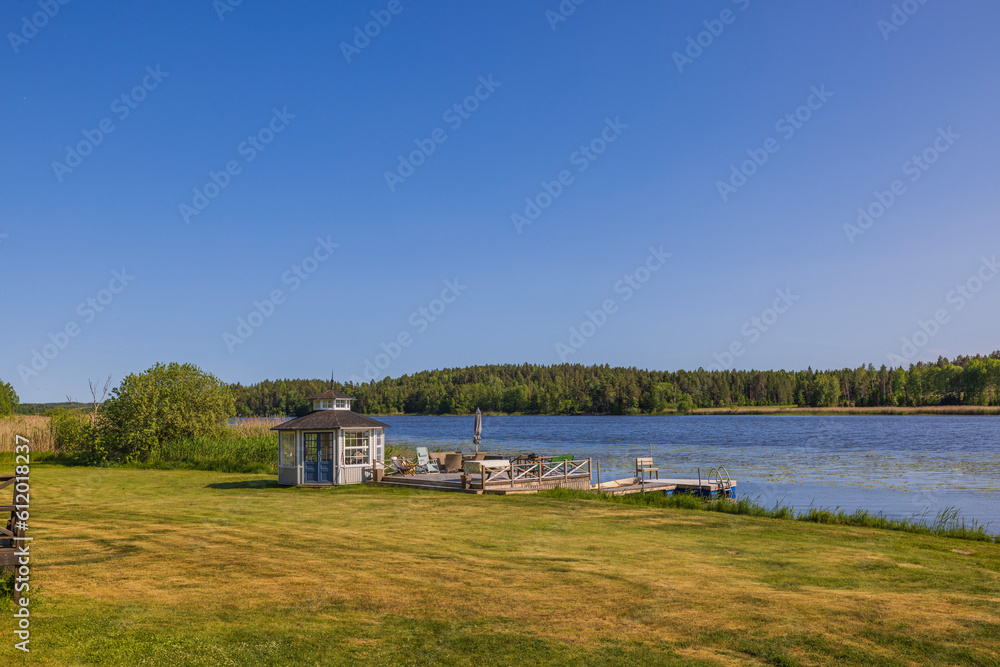 Beautiful view of utility building on lake shore on sunny day. Sweden. Europe. Beautiful view of utility building on lake shore on sunny day. Sweden. Europe.