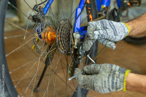 A mechanic is repairing a bicycle gear system.